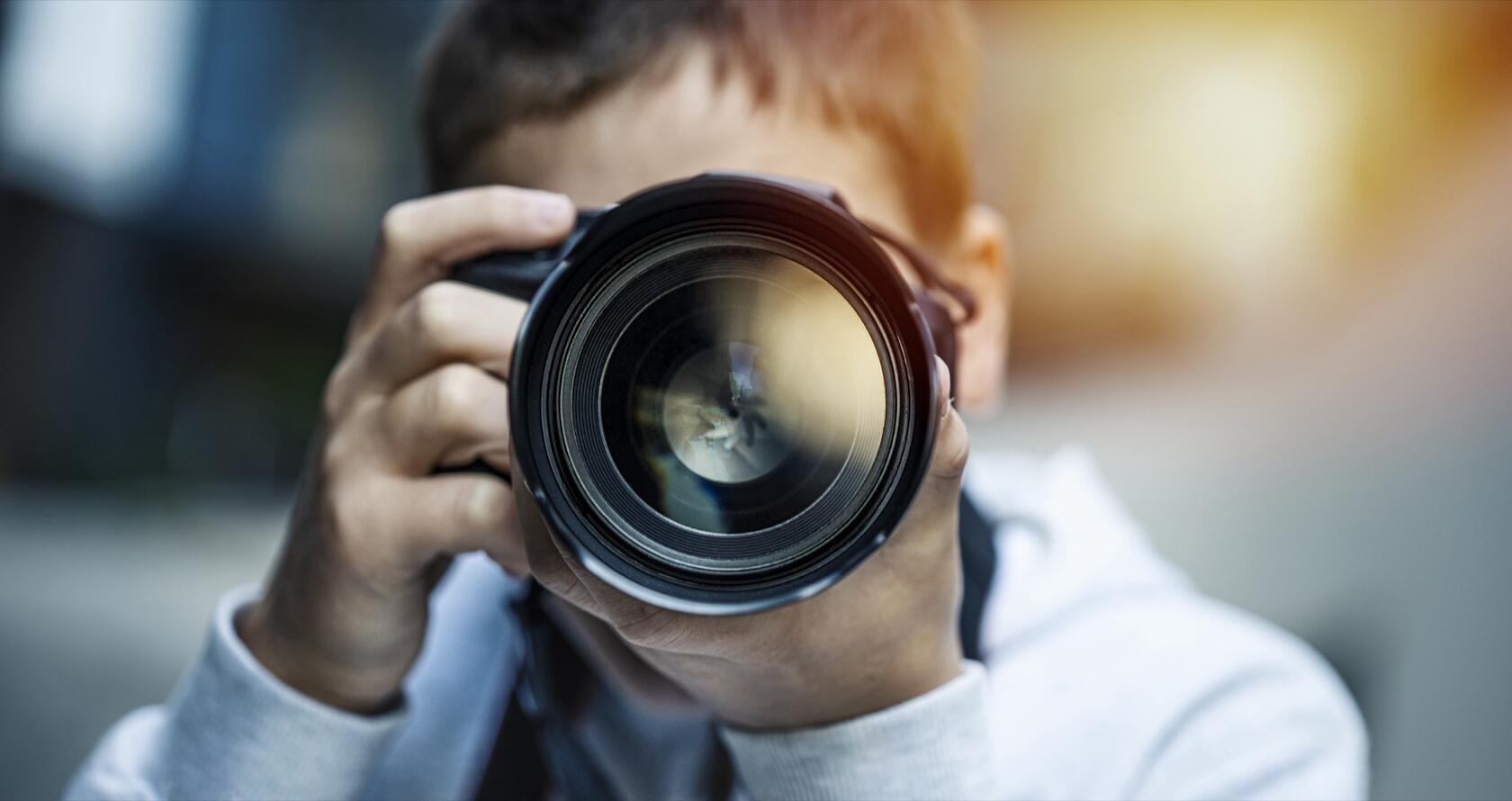 A person looking through a photo camera