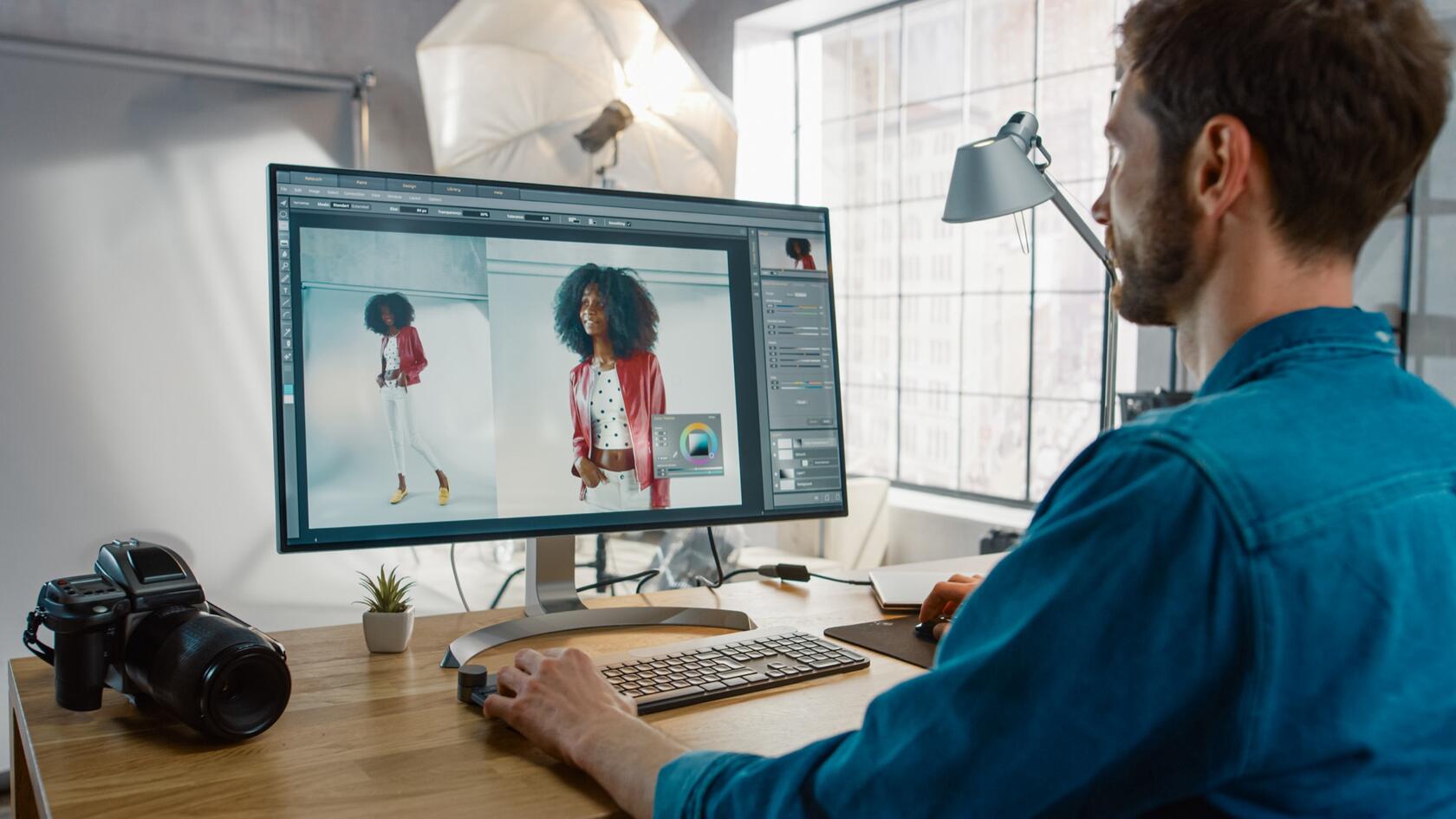 A person in a photo studio, editing images on a computer screen