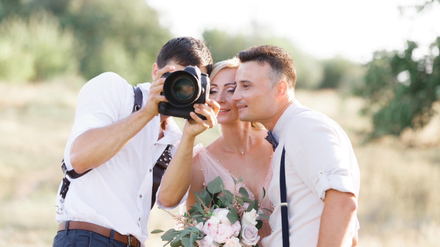 A photographer showing images on a camera during a wedding shoot