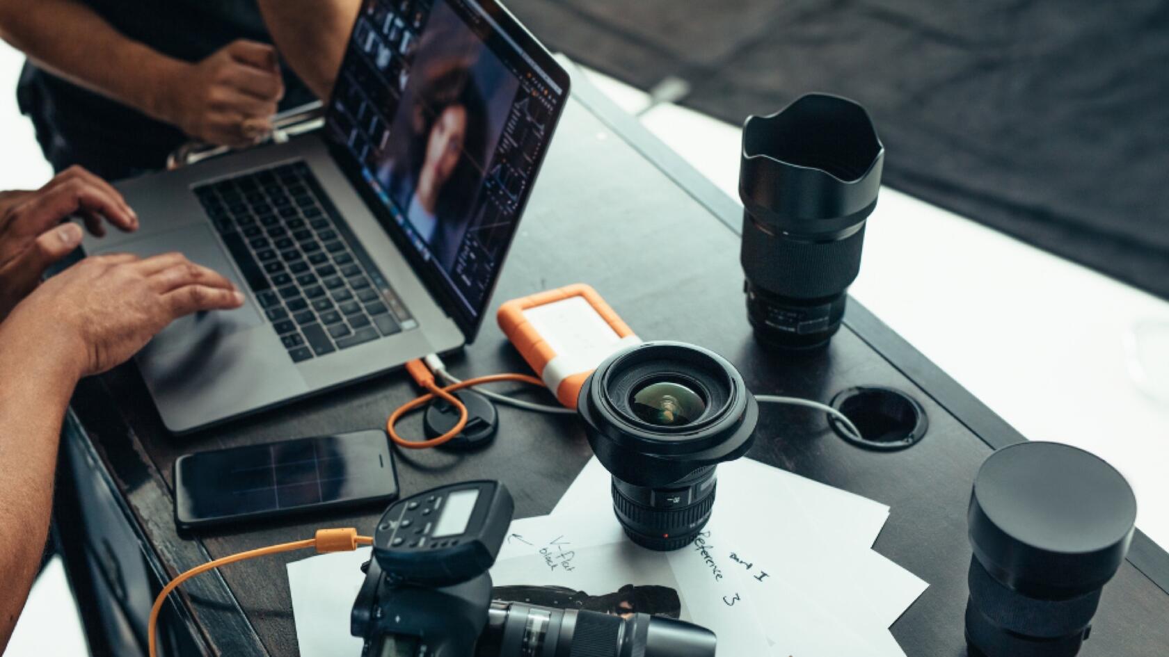 A person working on a laptop with a camera in front of them