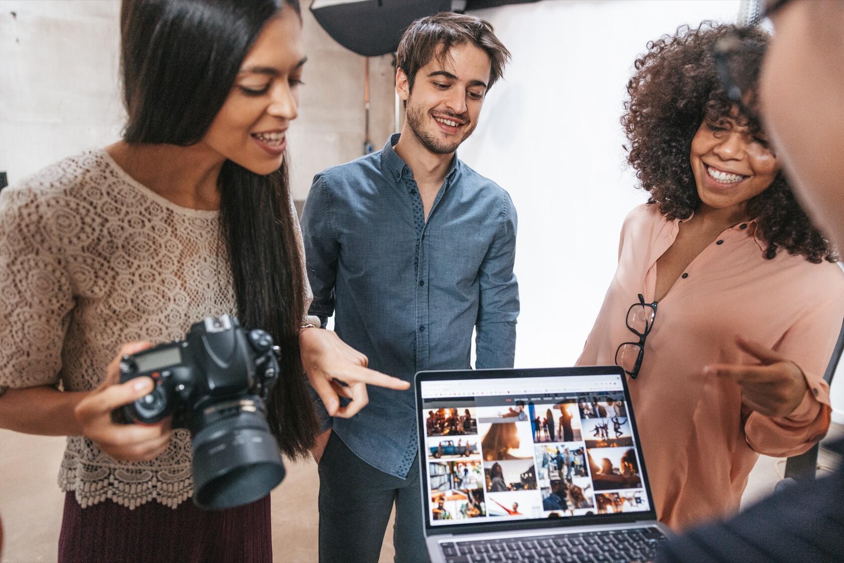 people smiling and discussing images from a photo shoot