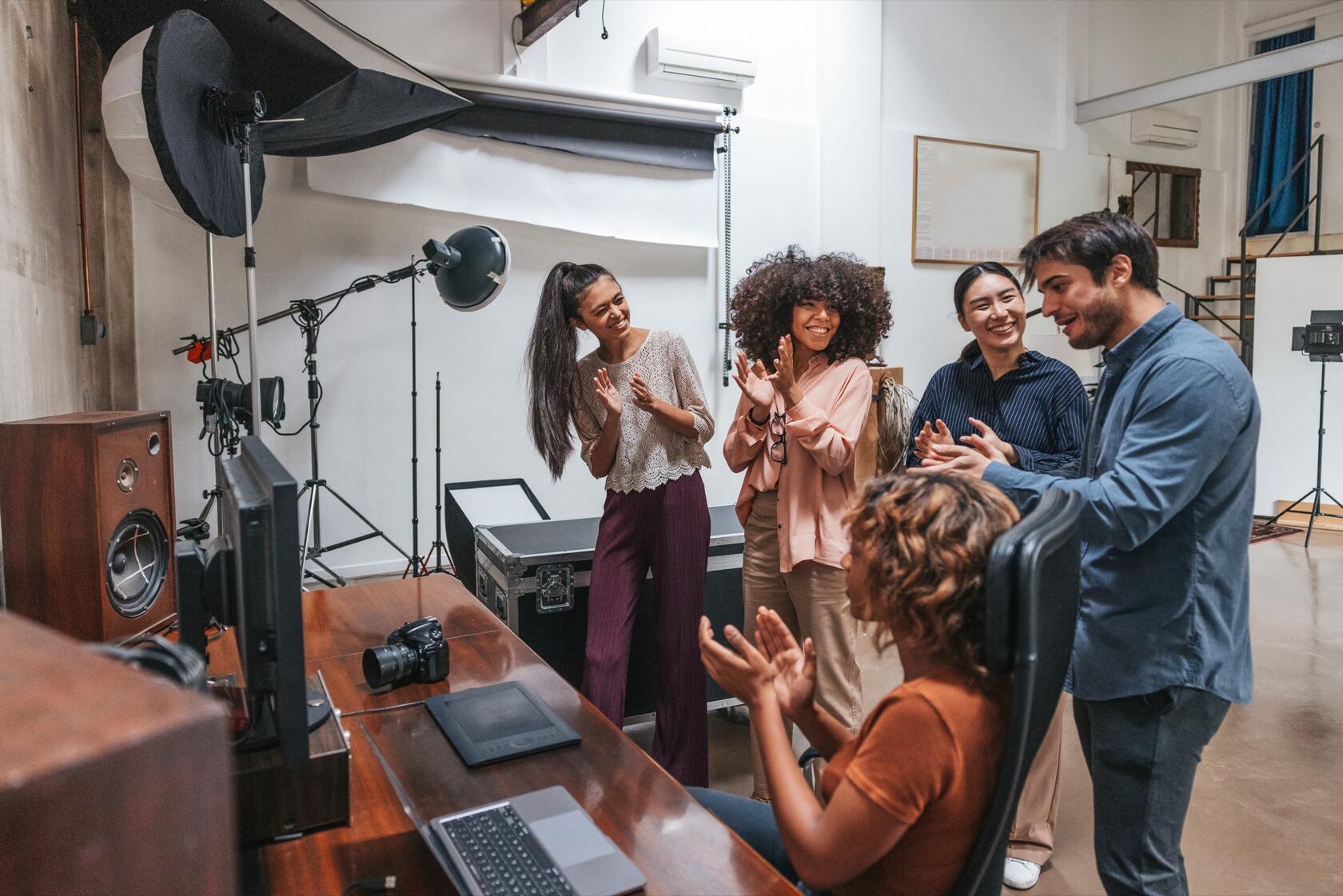 five persons applauding in a photo studio setting