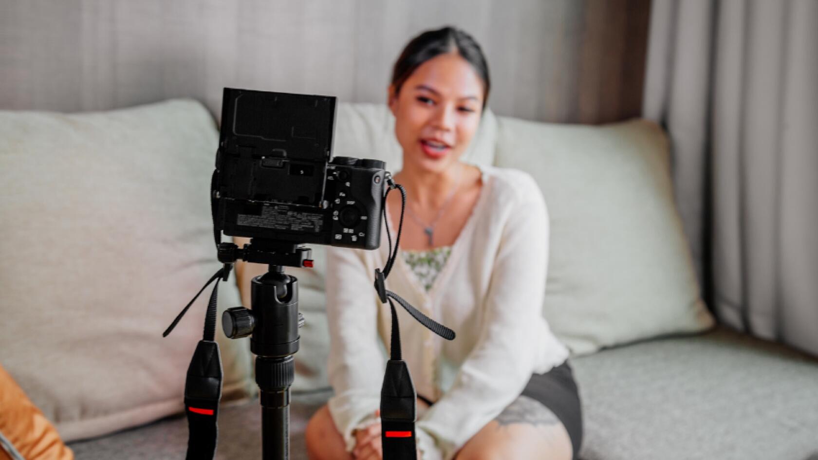 A person sitting on a couch with a camera on a tripod