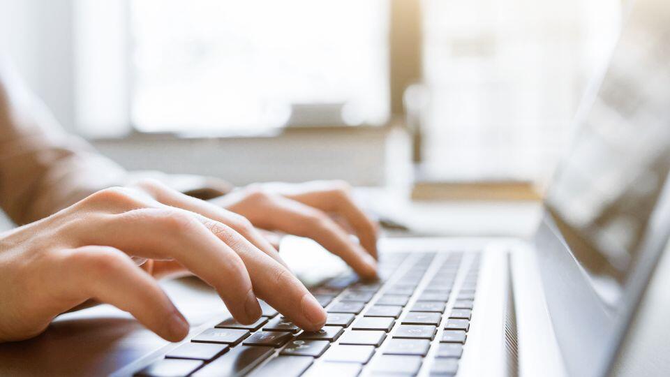 a person typing on a laptop keyboard