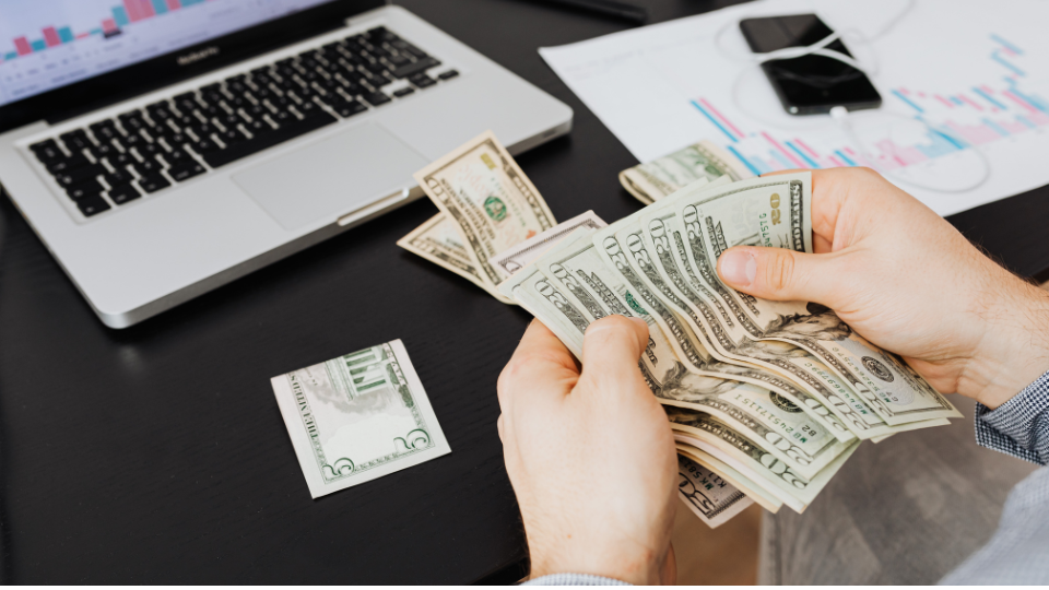 A person sitting on a desk, counting money