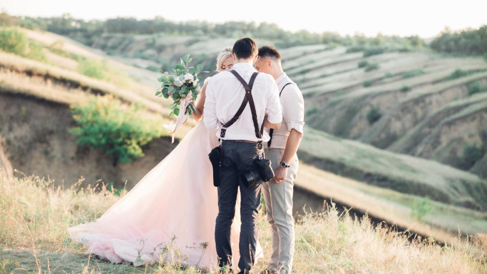 A couple standing on a hill in the middle of a field